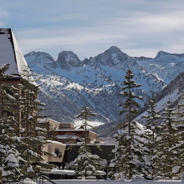 a snowy mountain range with buildings and trees