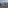 Snowy mountain resort with buildings, evergreen trees, and majestic peaks.