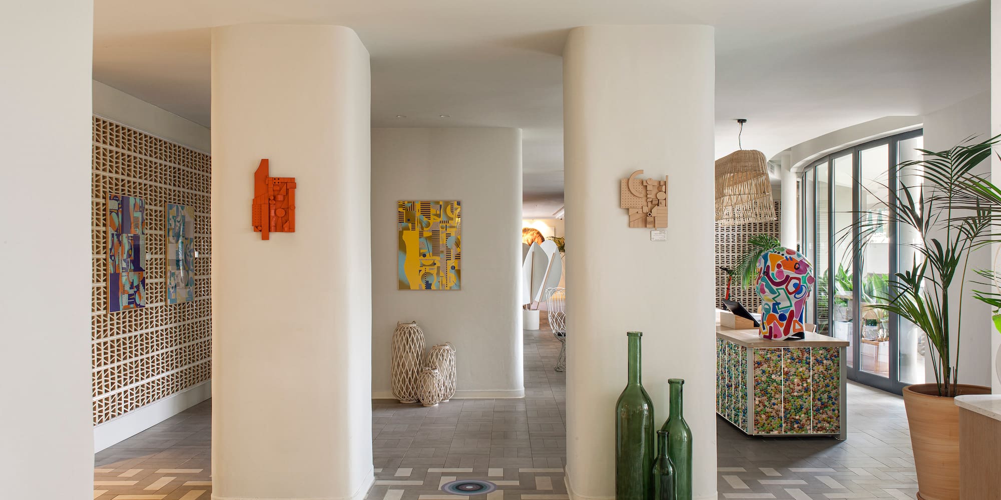 a room with white pillars and art on the wall