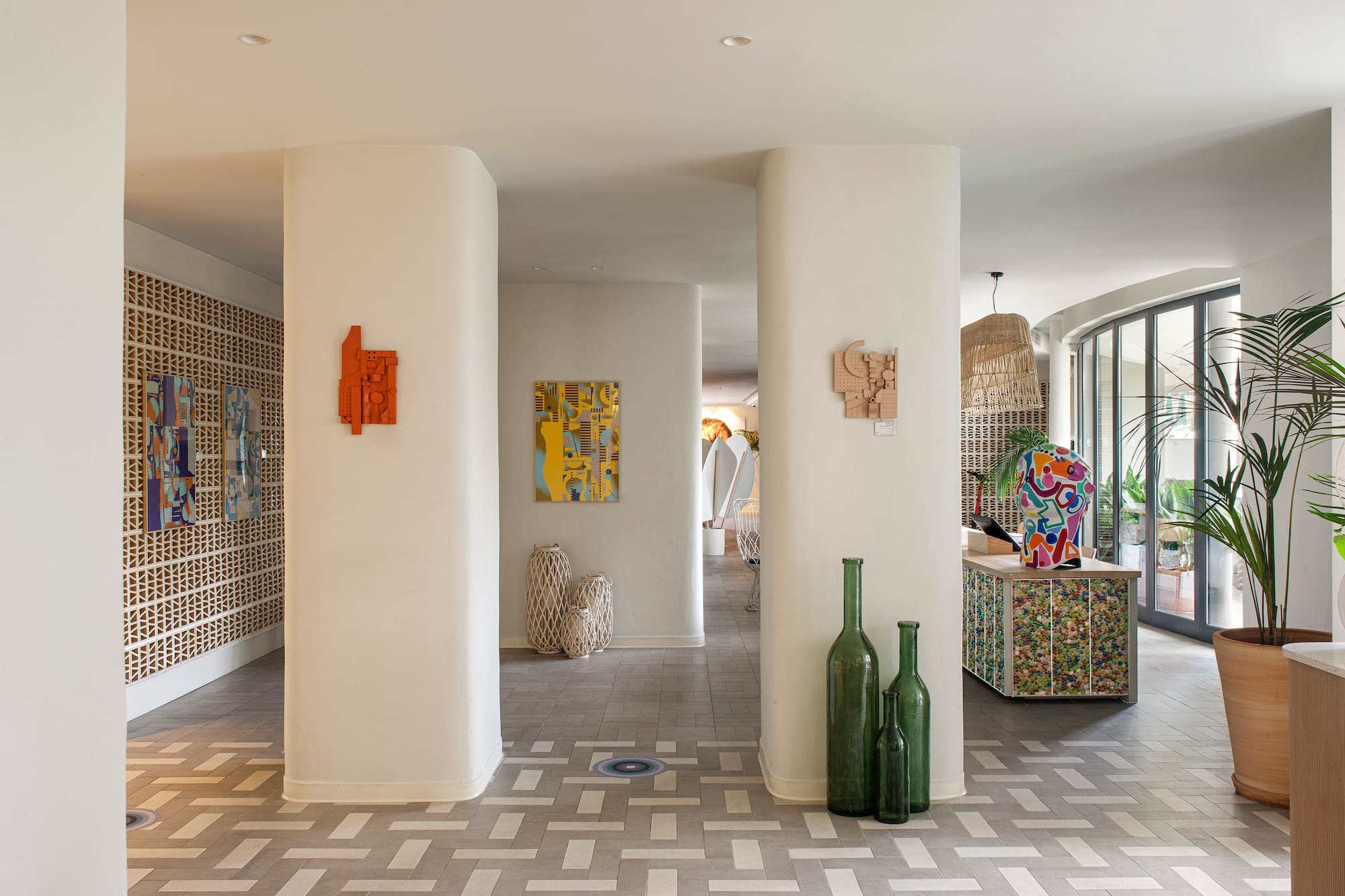Modern lobby with abstract art, geometric tiled floor, and contemporary decor.