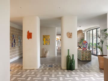 a room with white pillars and art on the wall