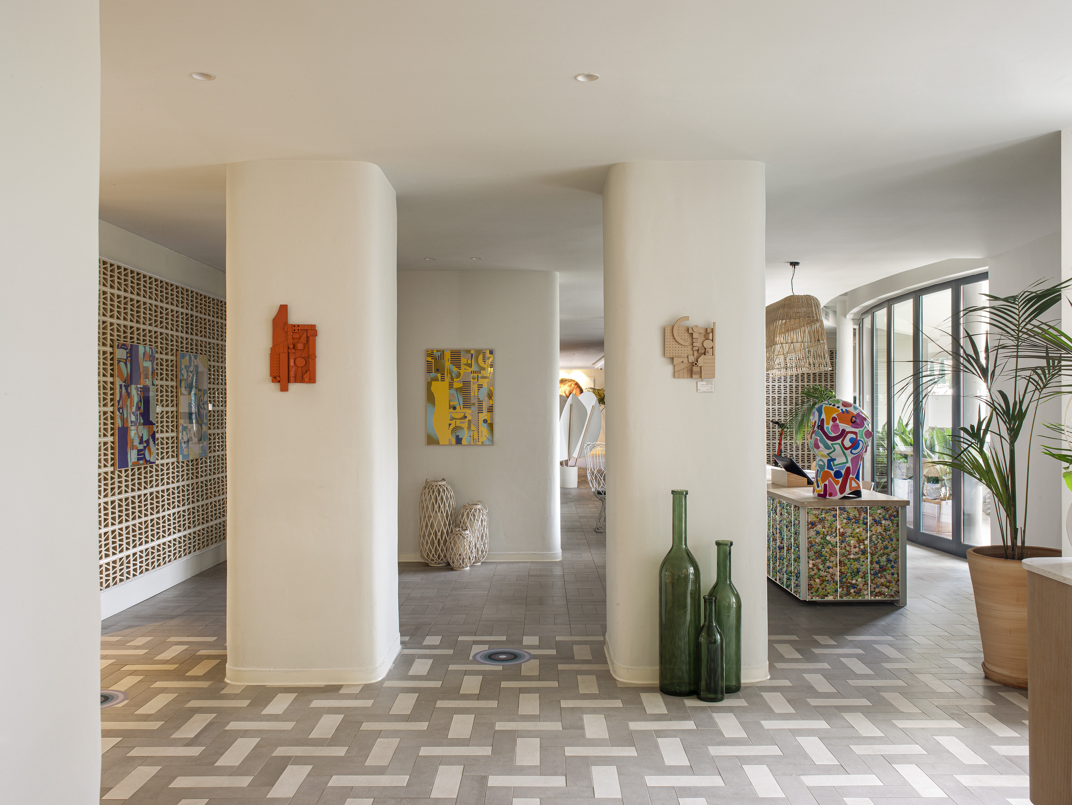 Modern lobby with abstract art, geometric tiled floor, and contemporary decor.