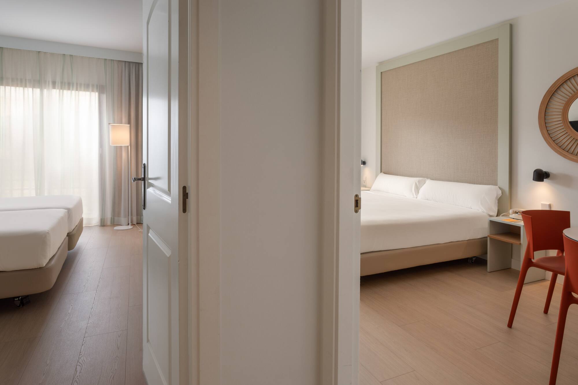 Two hotel rooms with twin and double beds, modern interior, light wood floor.