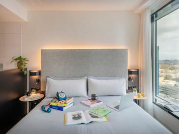 a bed with a laptop and books on it