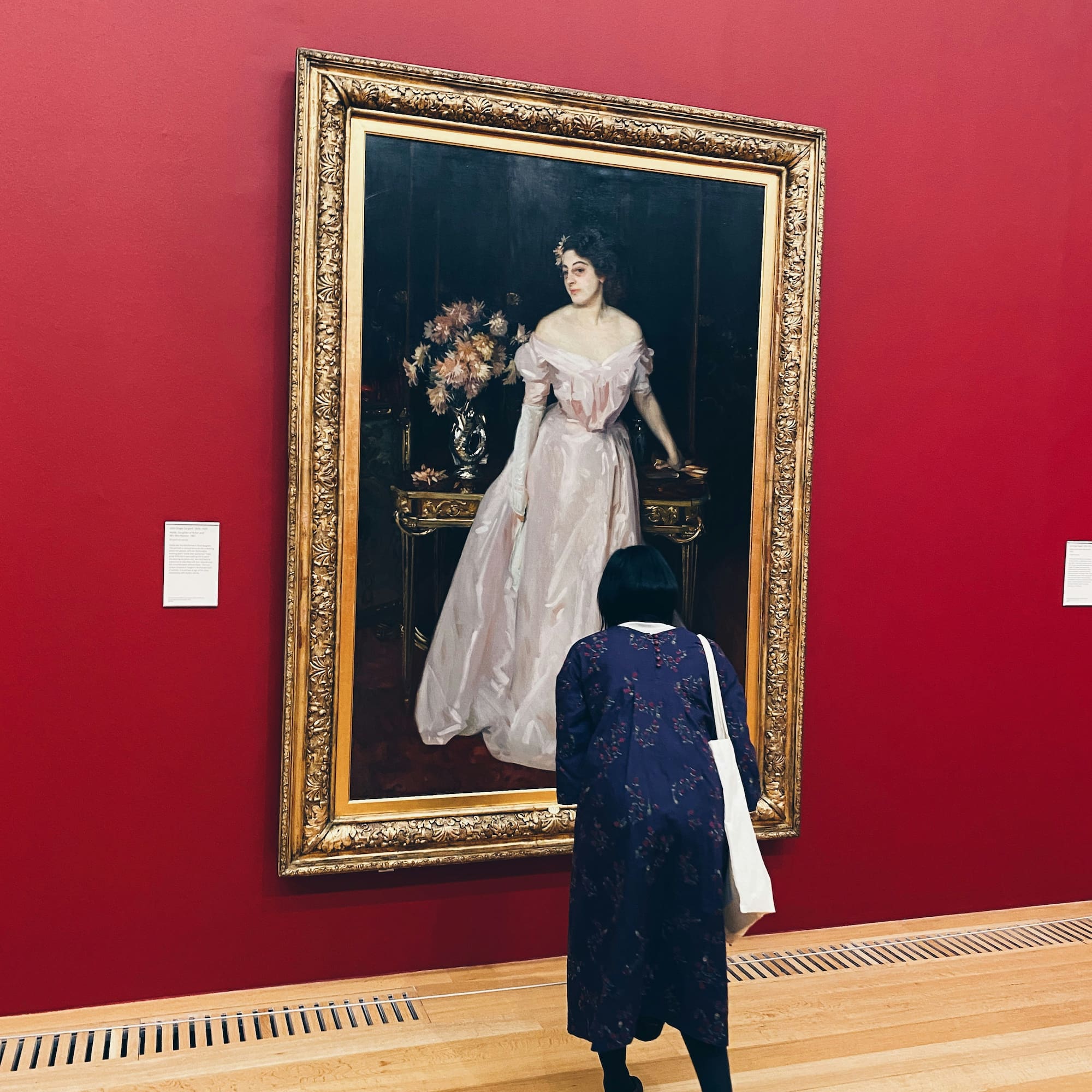 a woman looking at a painting on a wall