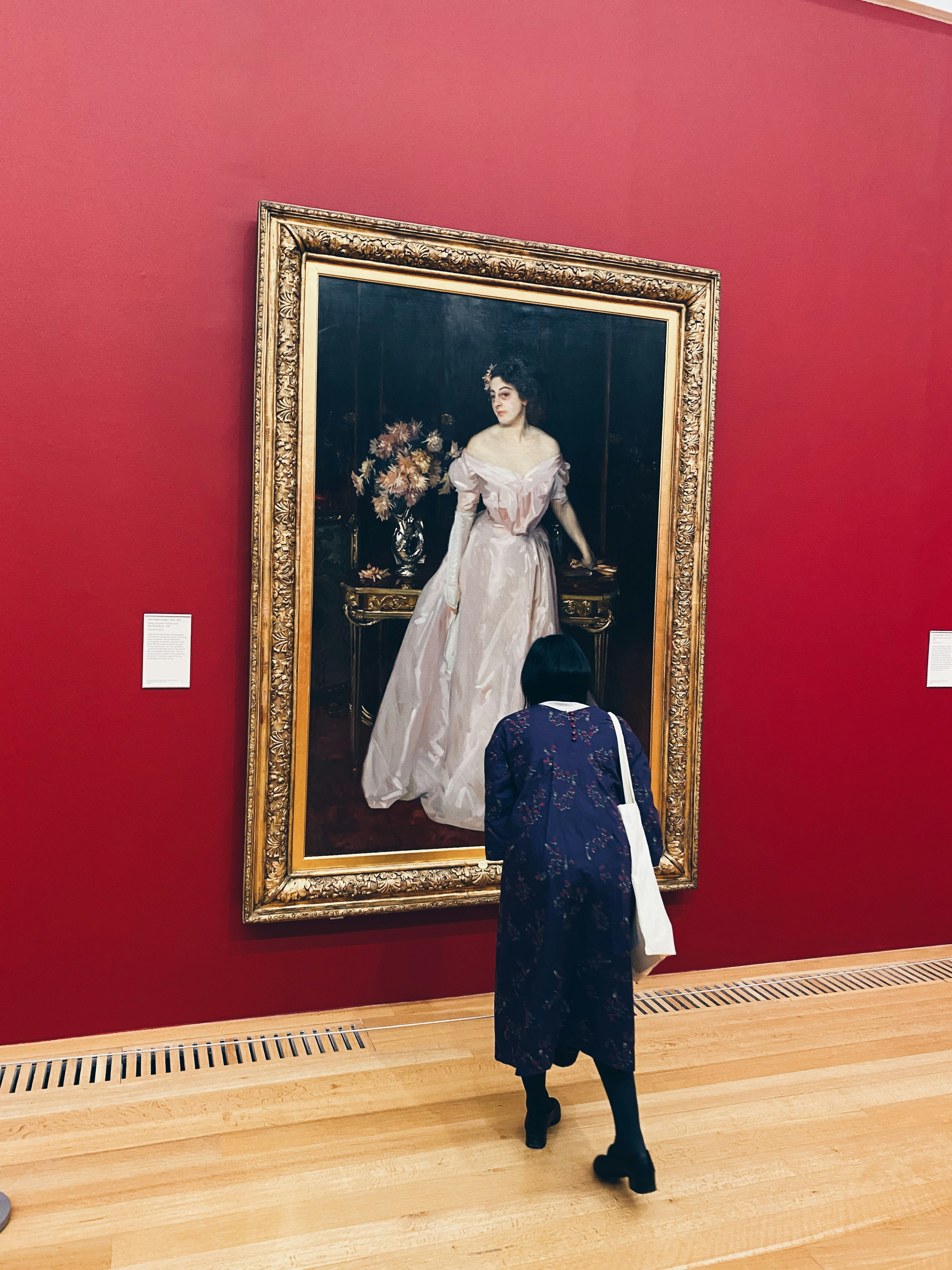 a woman looking at a painting on a wall
