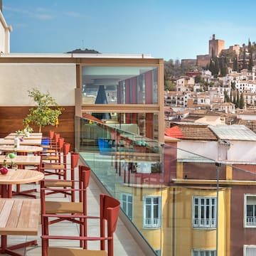 a table and chairs on a balcony overlooking a city