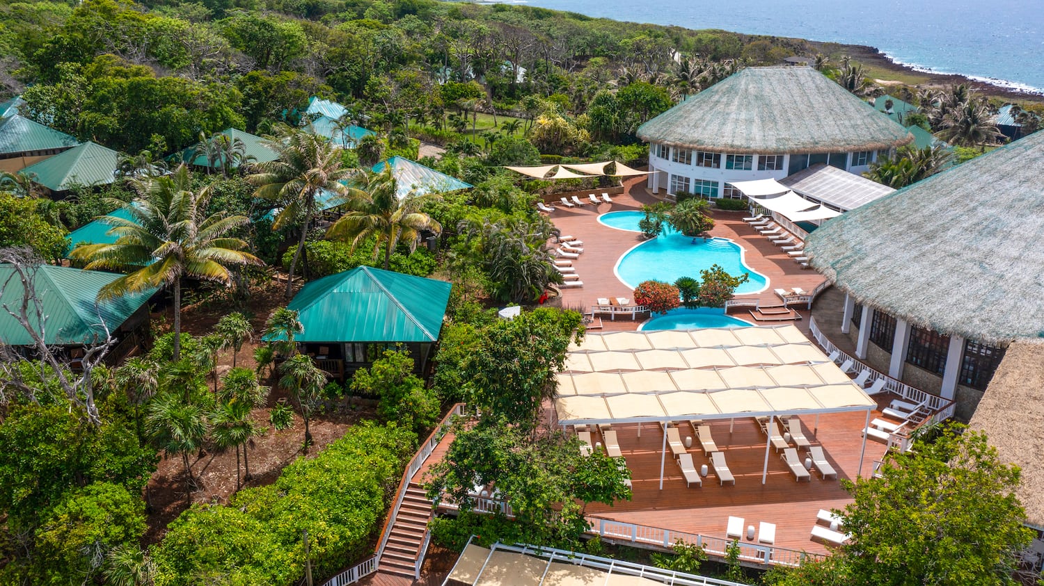 a pool and a building with trees and a body of water