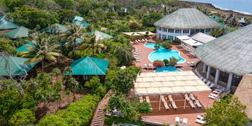 a pool and a building with trees and a body of water