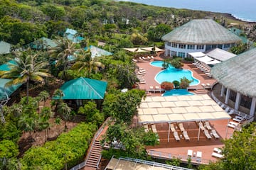 a pool and a building with trees and a body of water