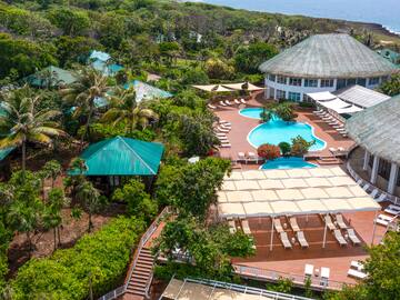 a pool and a building with trees and a body of water