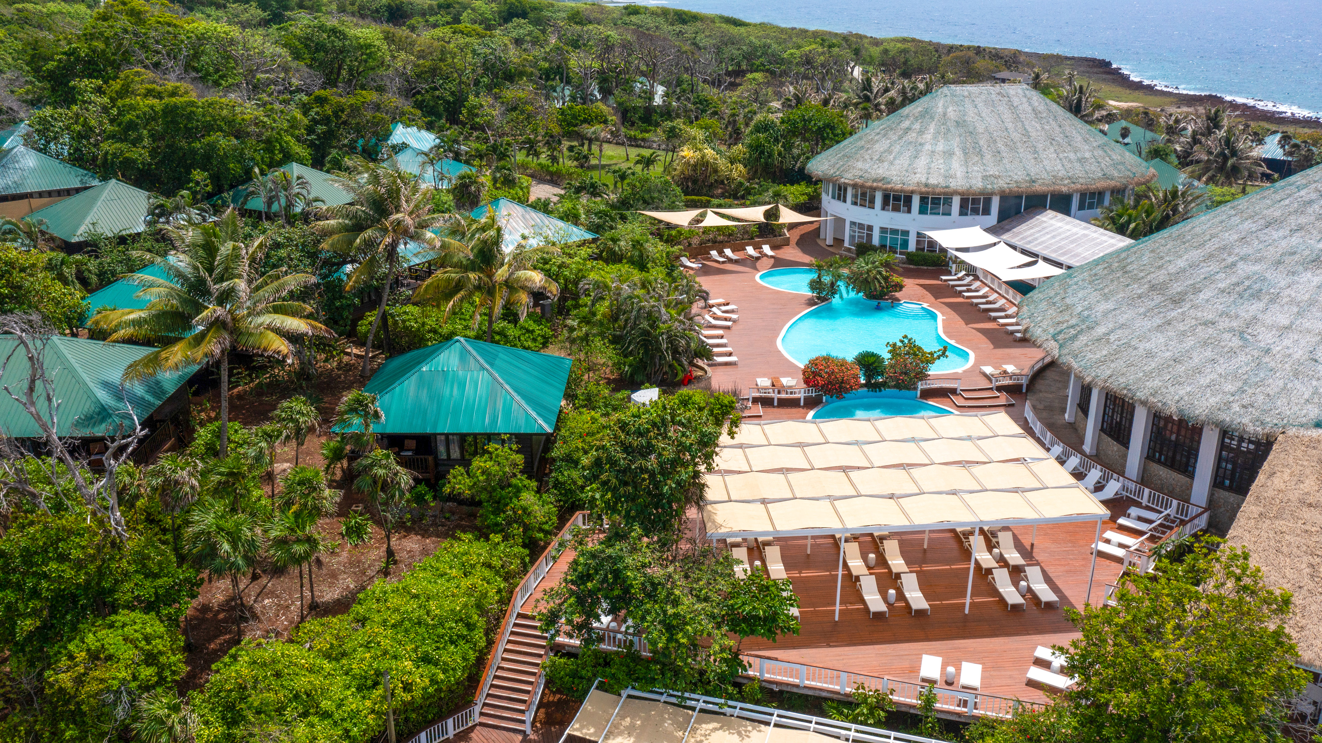 a pool and a building with trees and a body of water