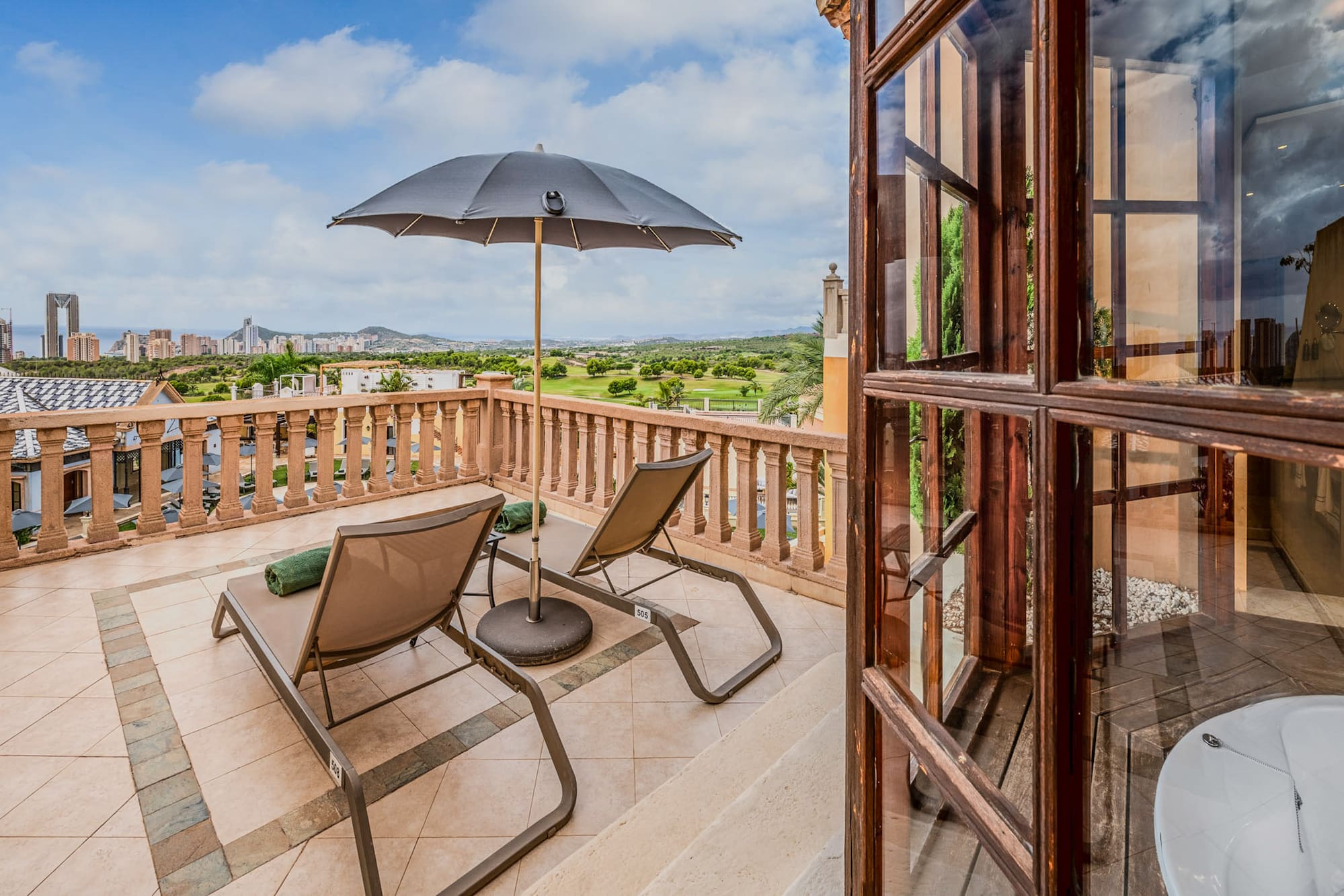 a patio with chairs and umbrella