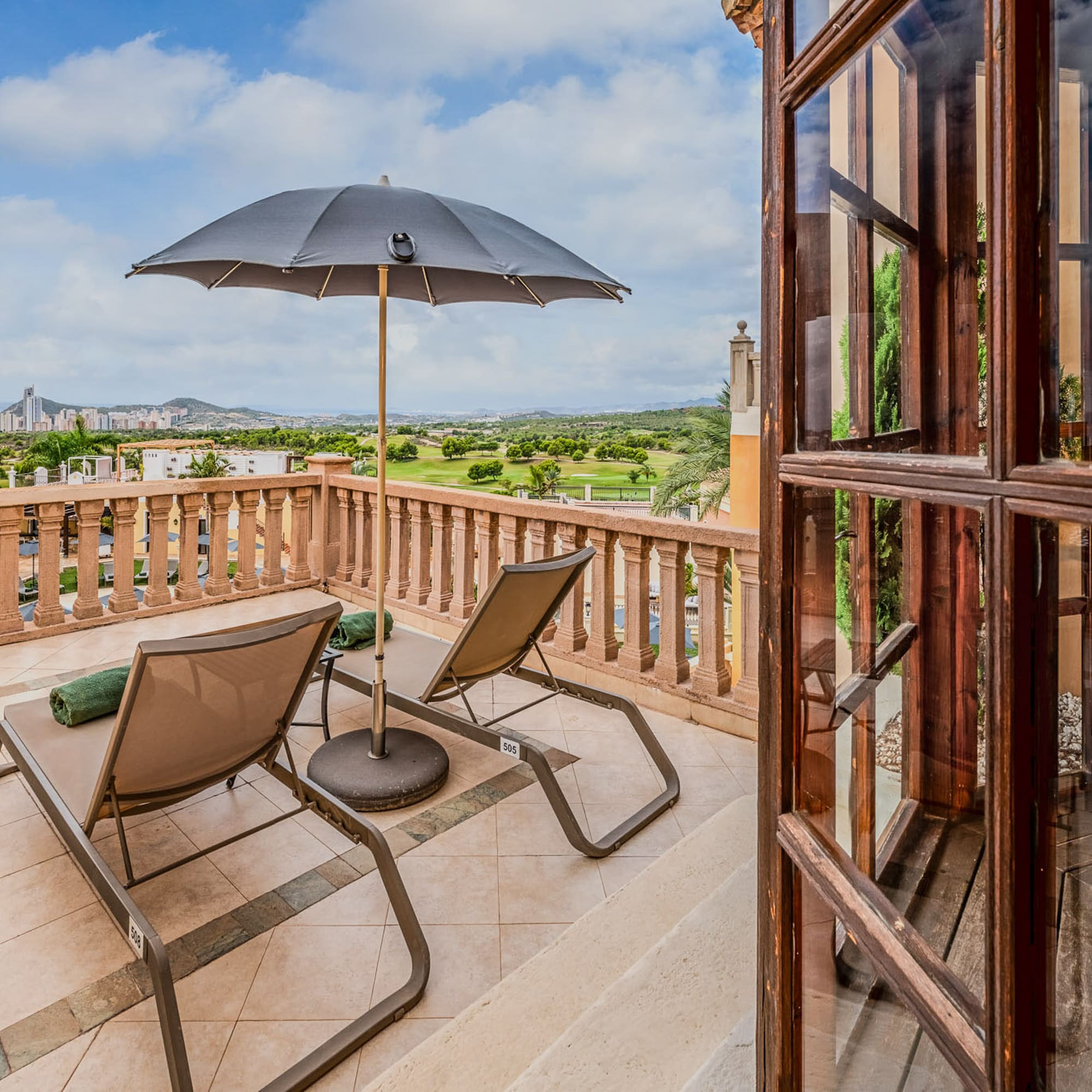 a patio with chairs and umbrella