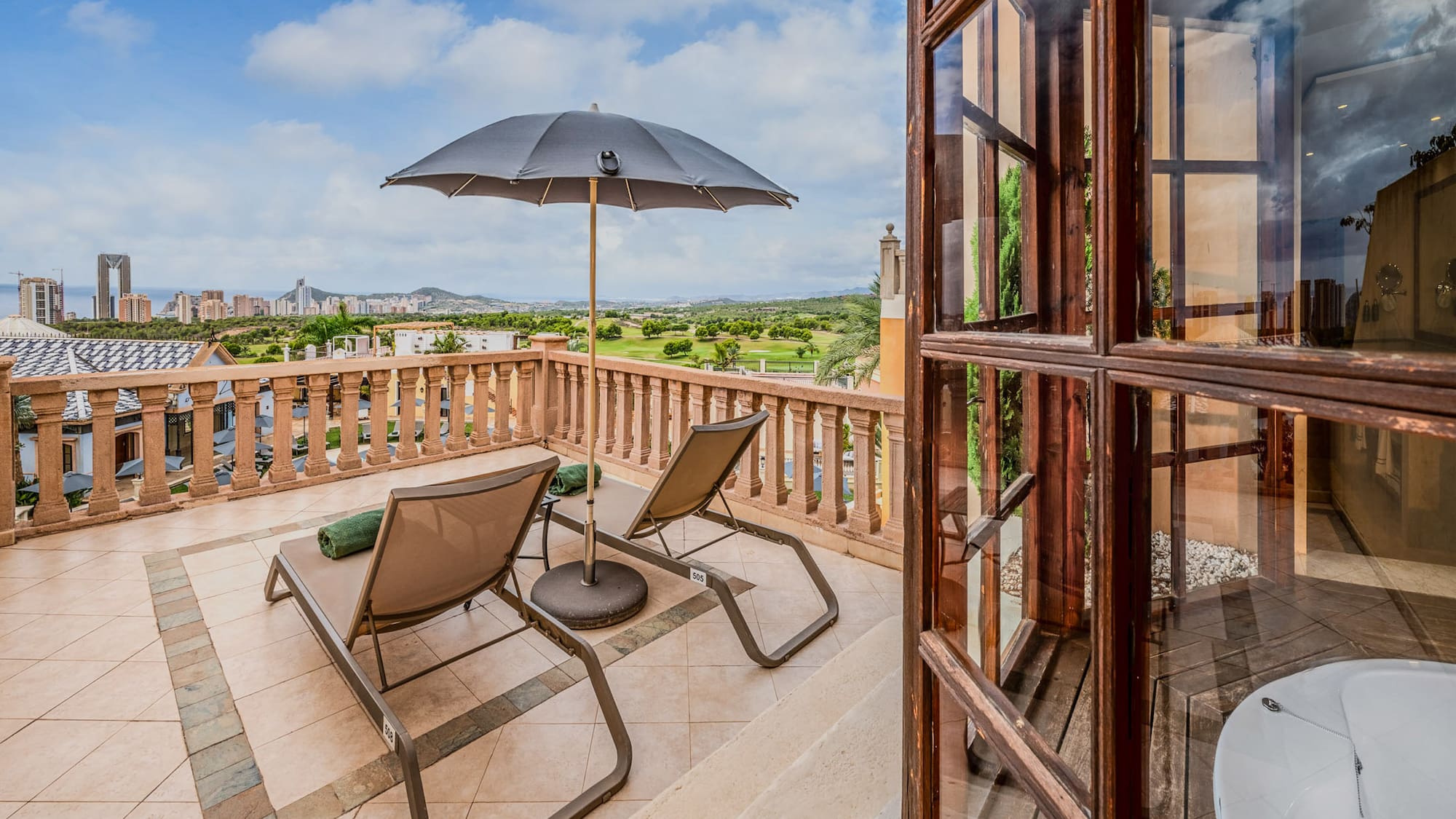 a patio with chairs and umbrella