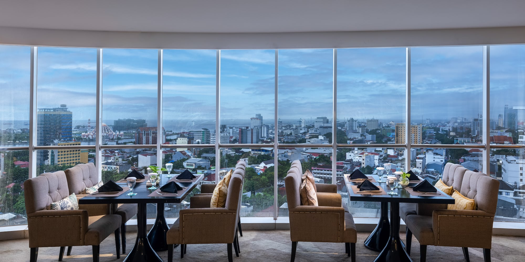 a restaurant with tables and chairs and a view of a city