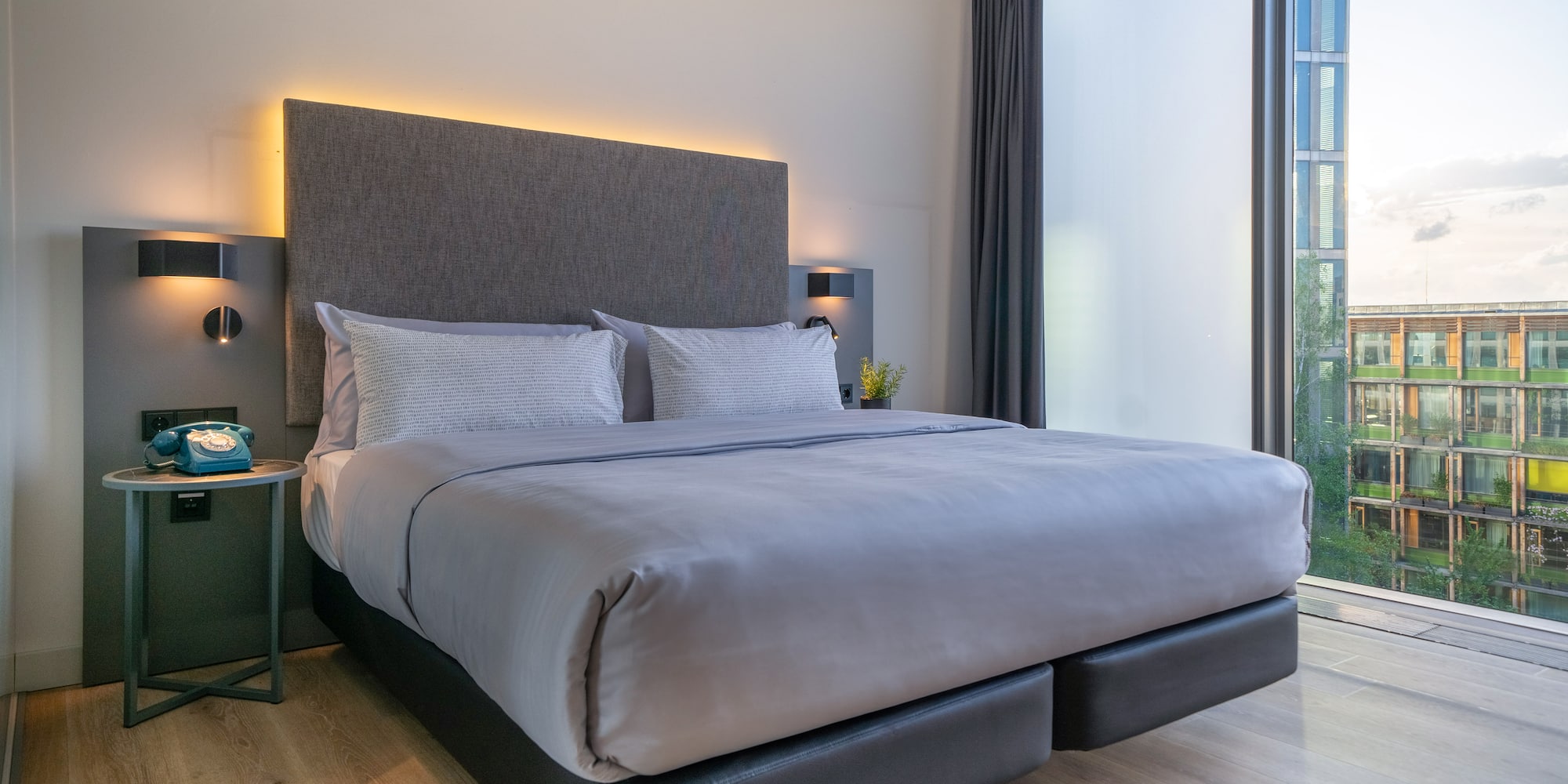 a bed with a headboard and a table with a lamp