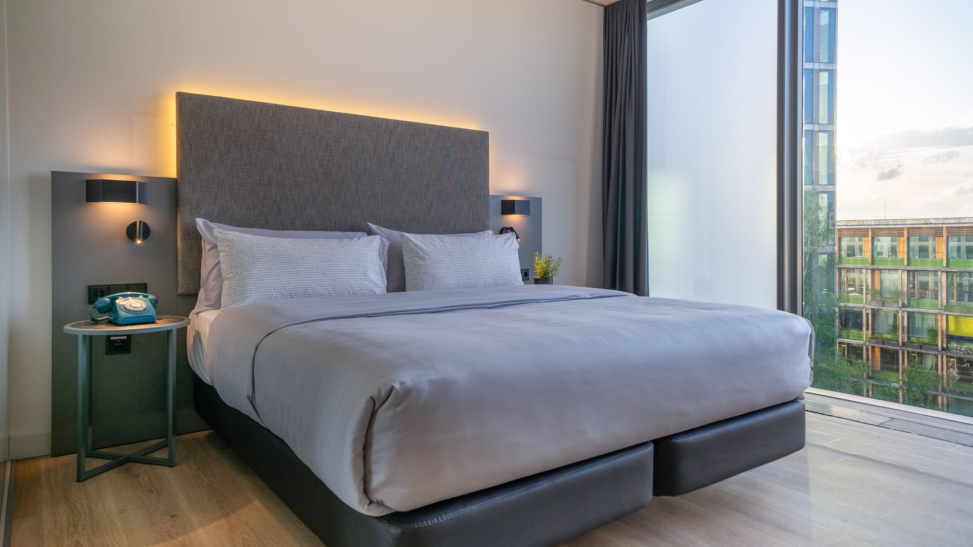 a bed with a headboard and a table with a lamp