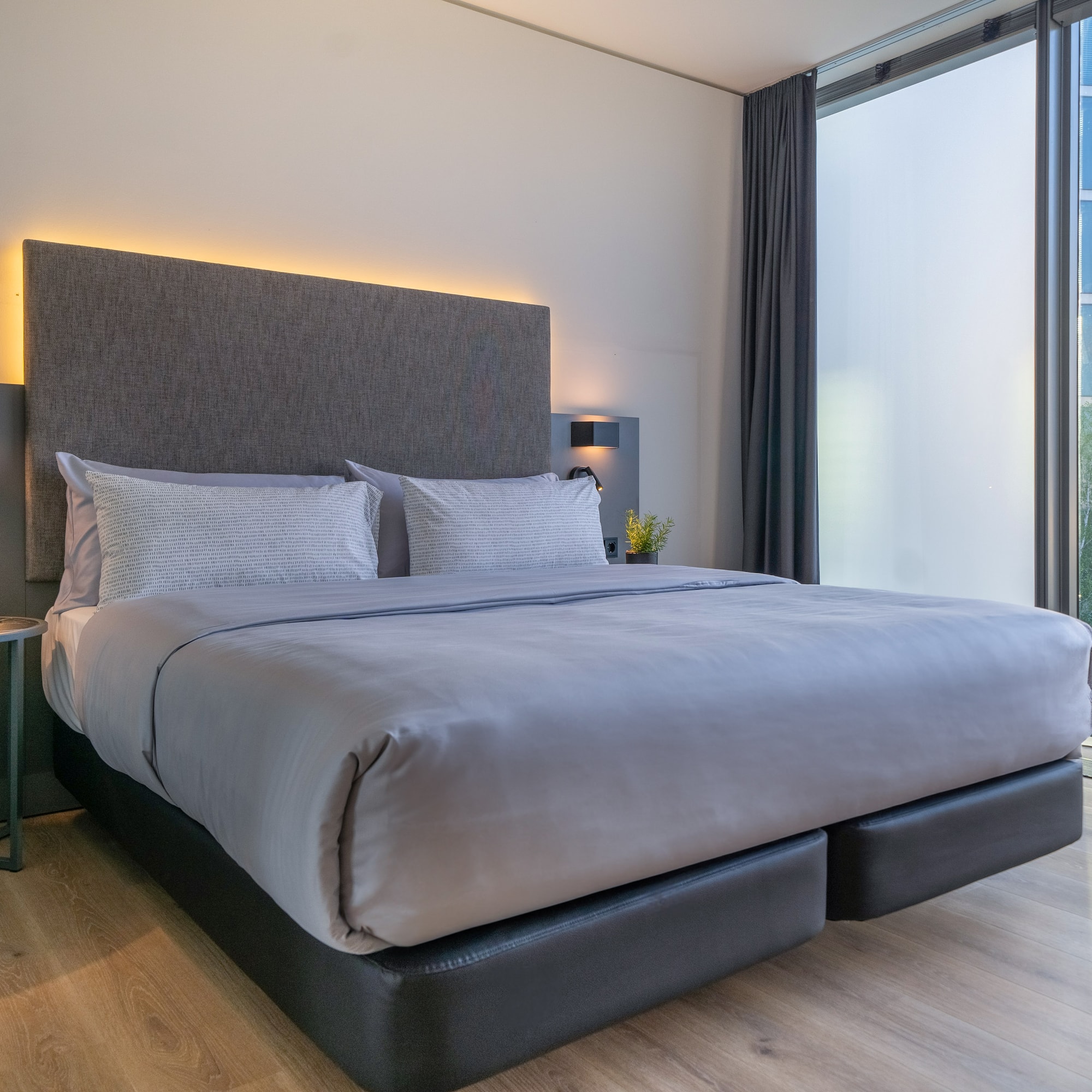 a bed with a headboard and a table with a lamp