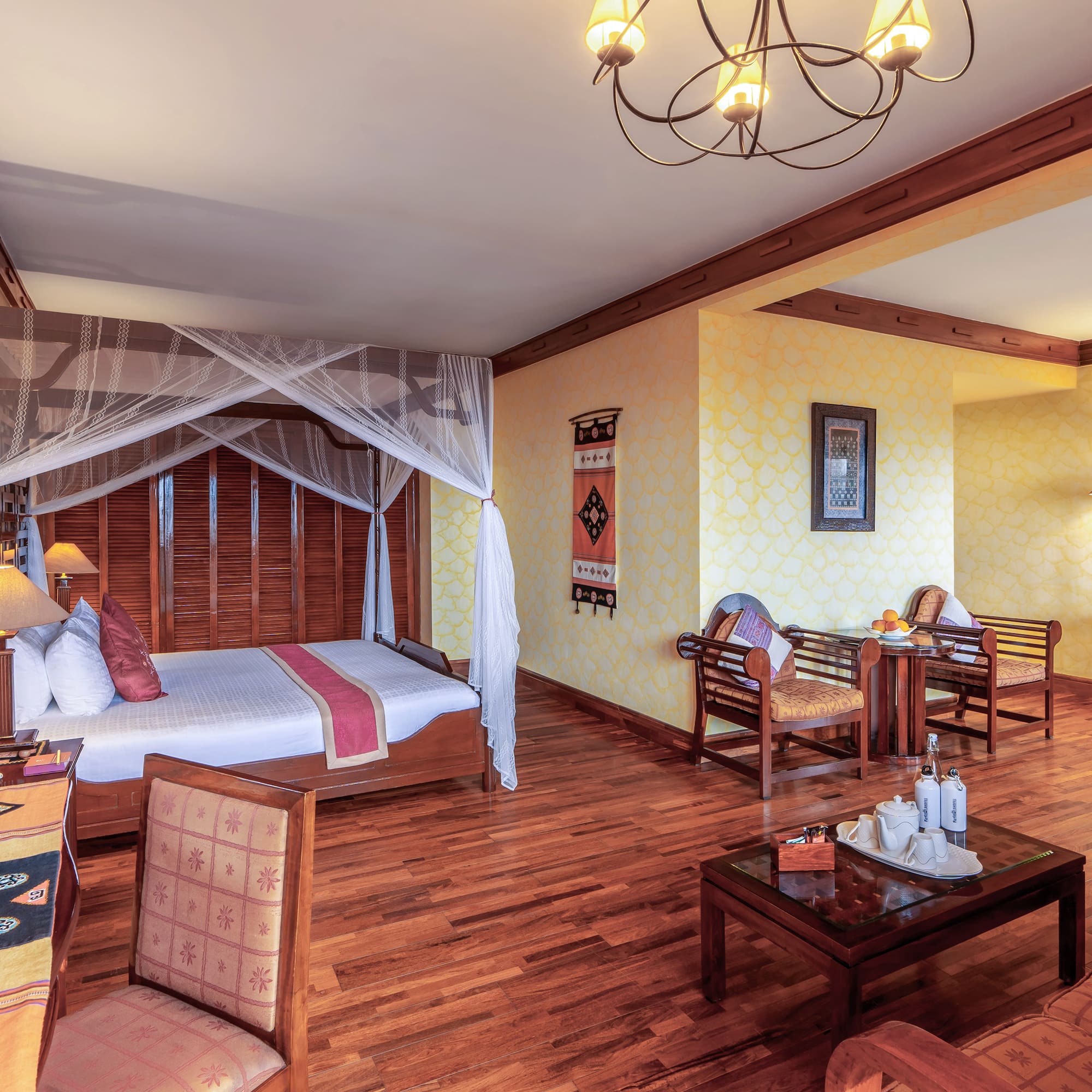 a room with a bed and chairs