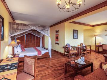 a room with a bed and chairs