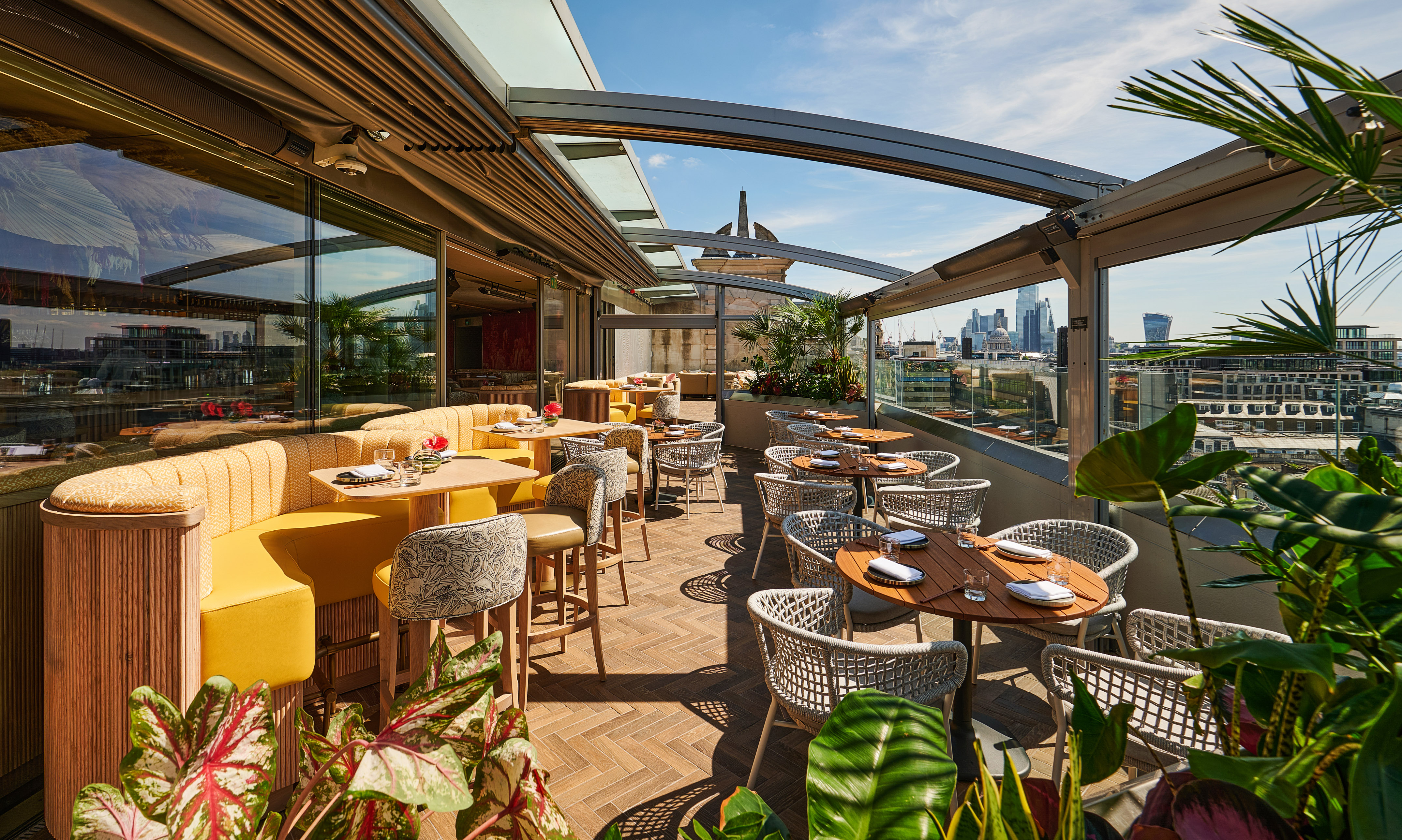 Elegant rooftop terrace with modern seating, London skyline, and lush greenery.