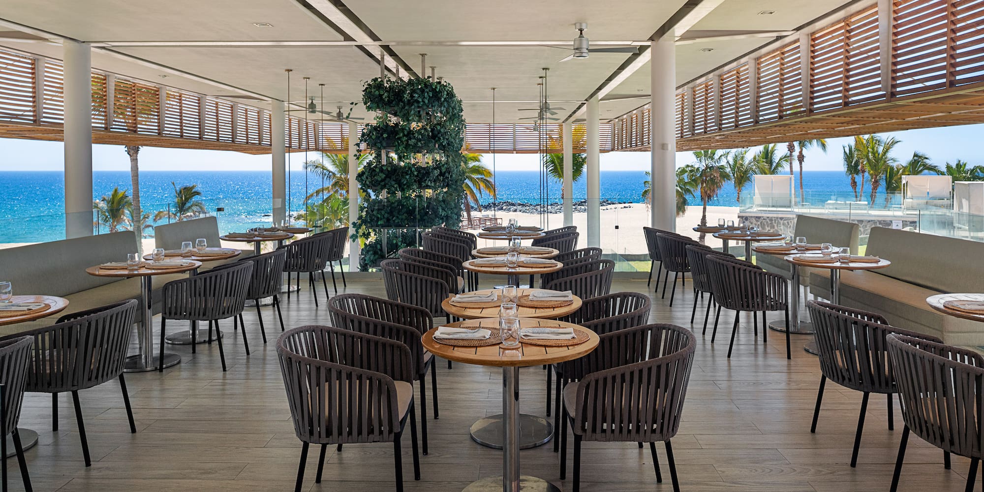a restaurant with tables and chairs on the beach