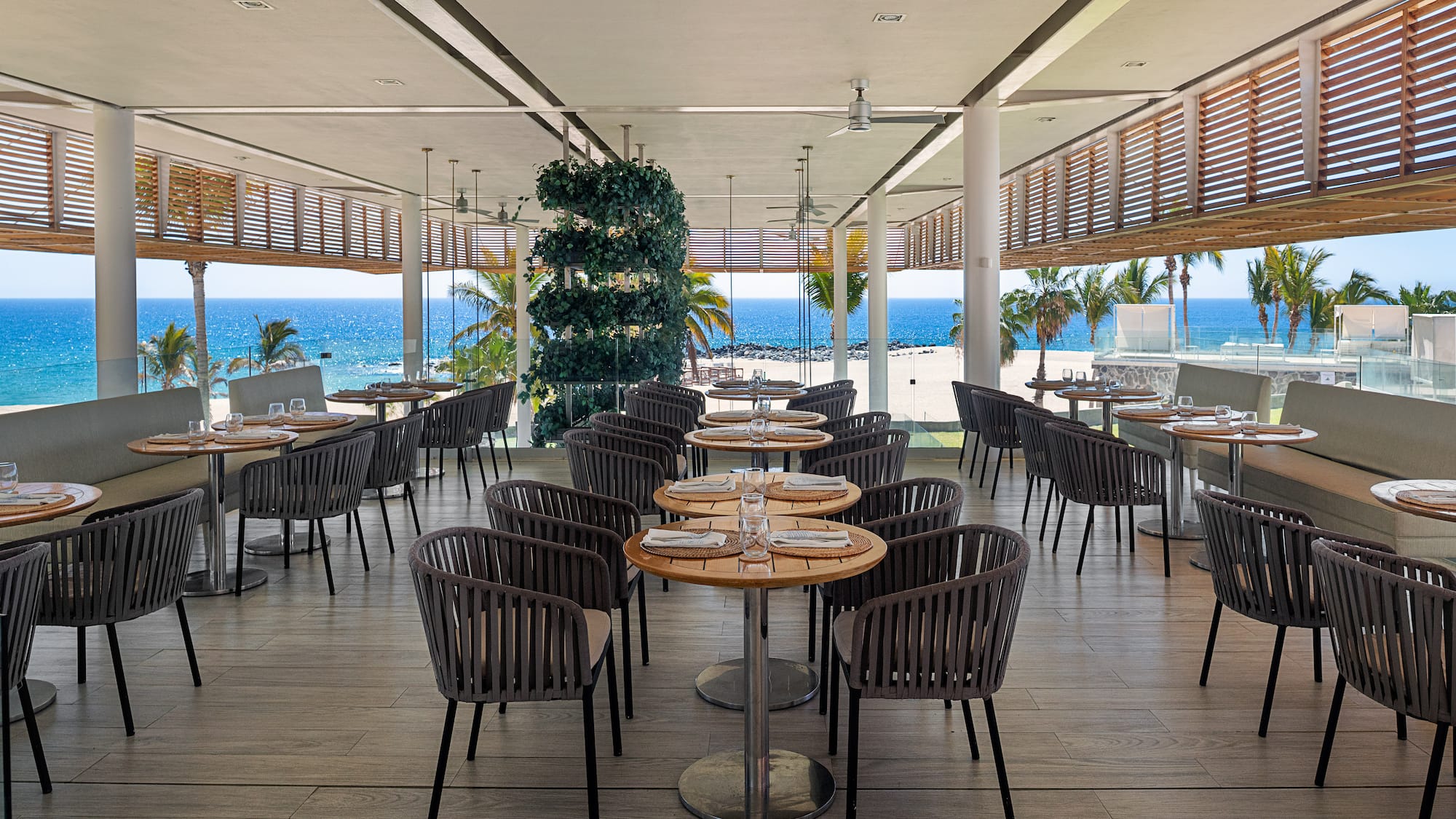 a restaurant with tables and chairs on the beach