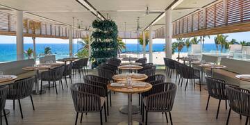 a restaurant with tables and chairs on the beach