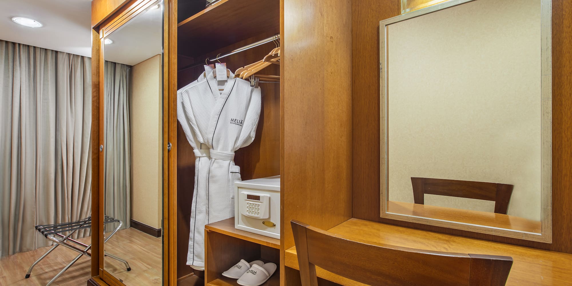 a closet with a robe and mirror