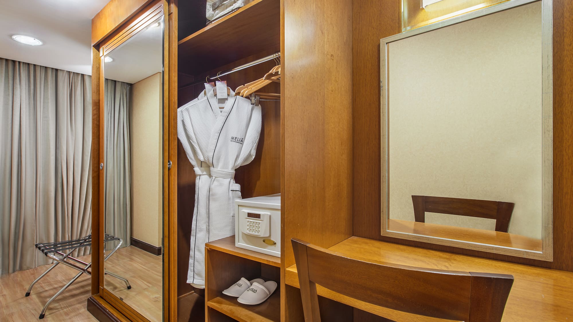 a closet with a robe and mirror