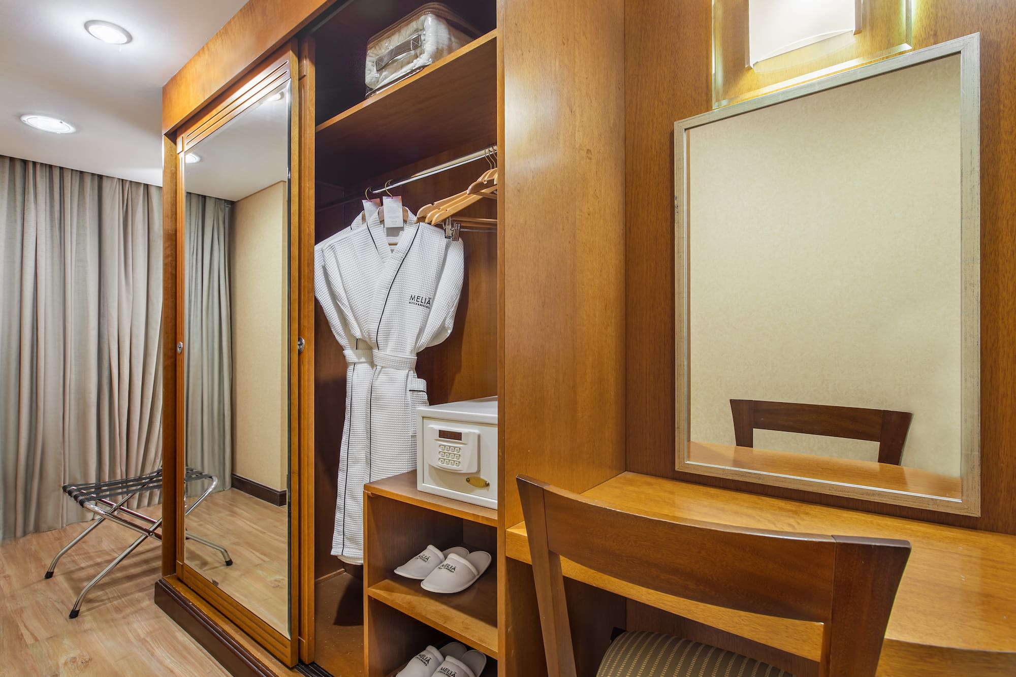 a closet with a robe and mirror