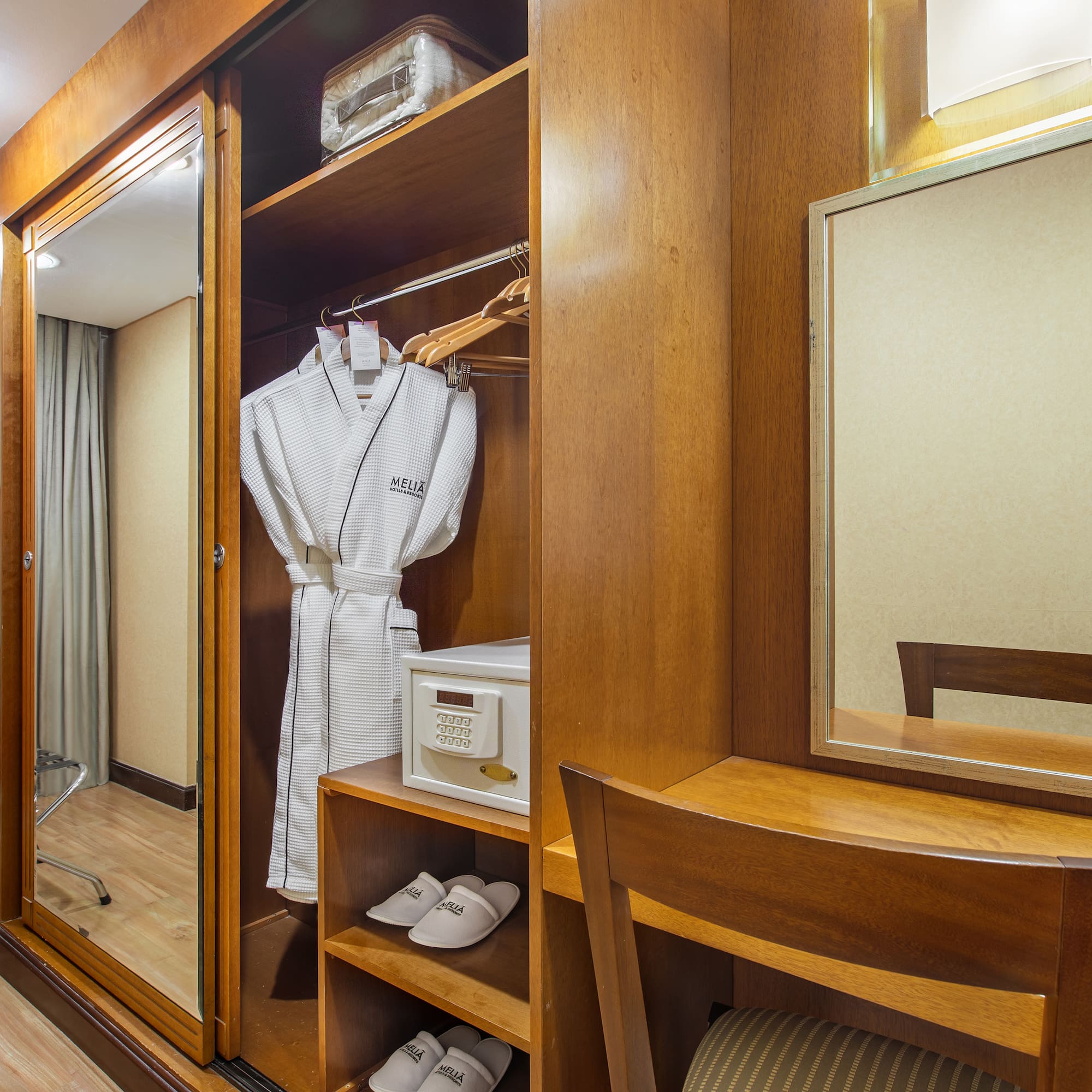 a closet with a robe and mirror