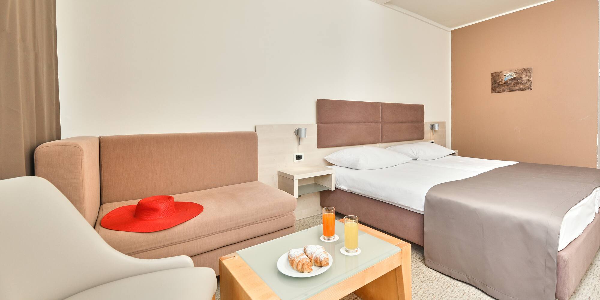a room with two beds and a table with food and drinks