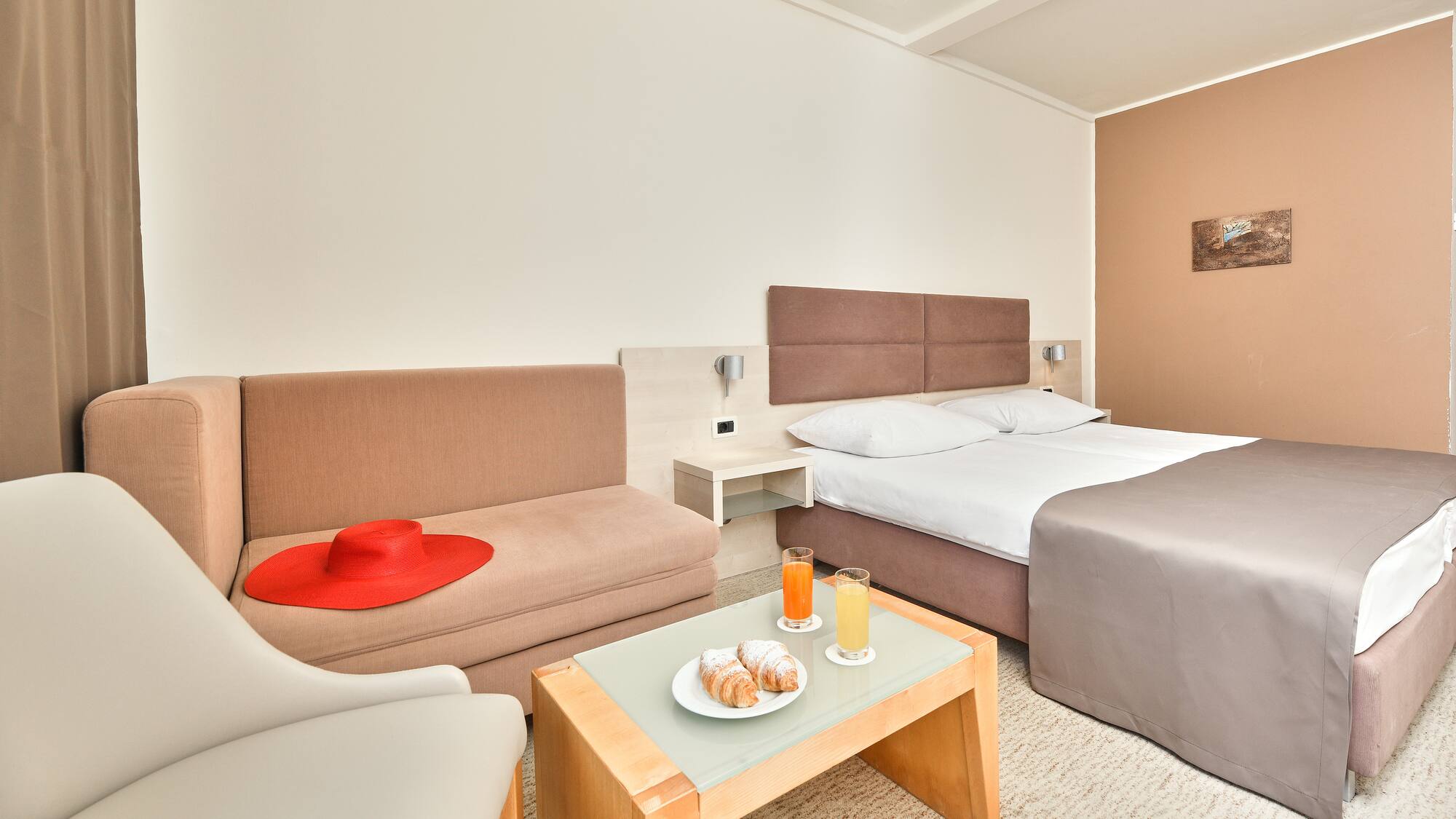 a room with two beds and a table with food and drinks