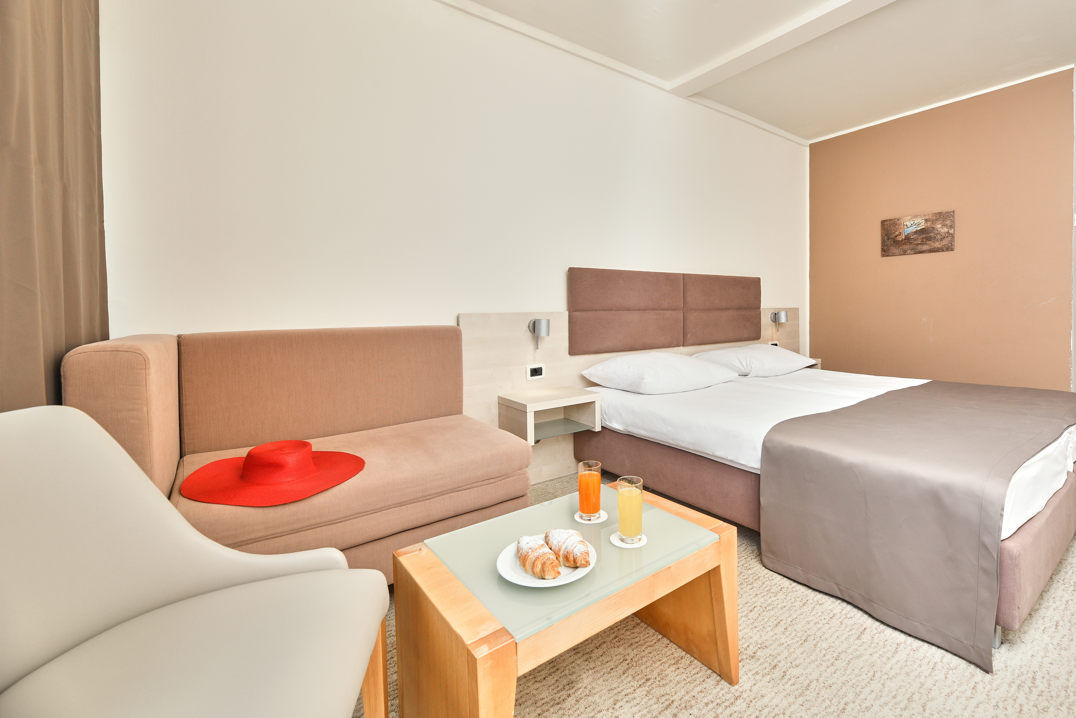 a room with two beds and a table with food and drinks