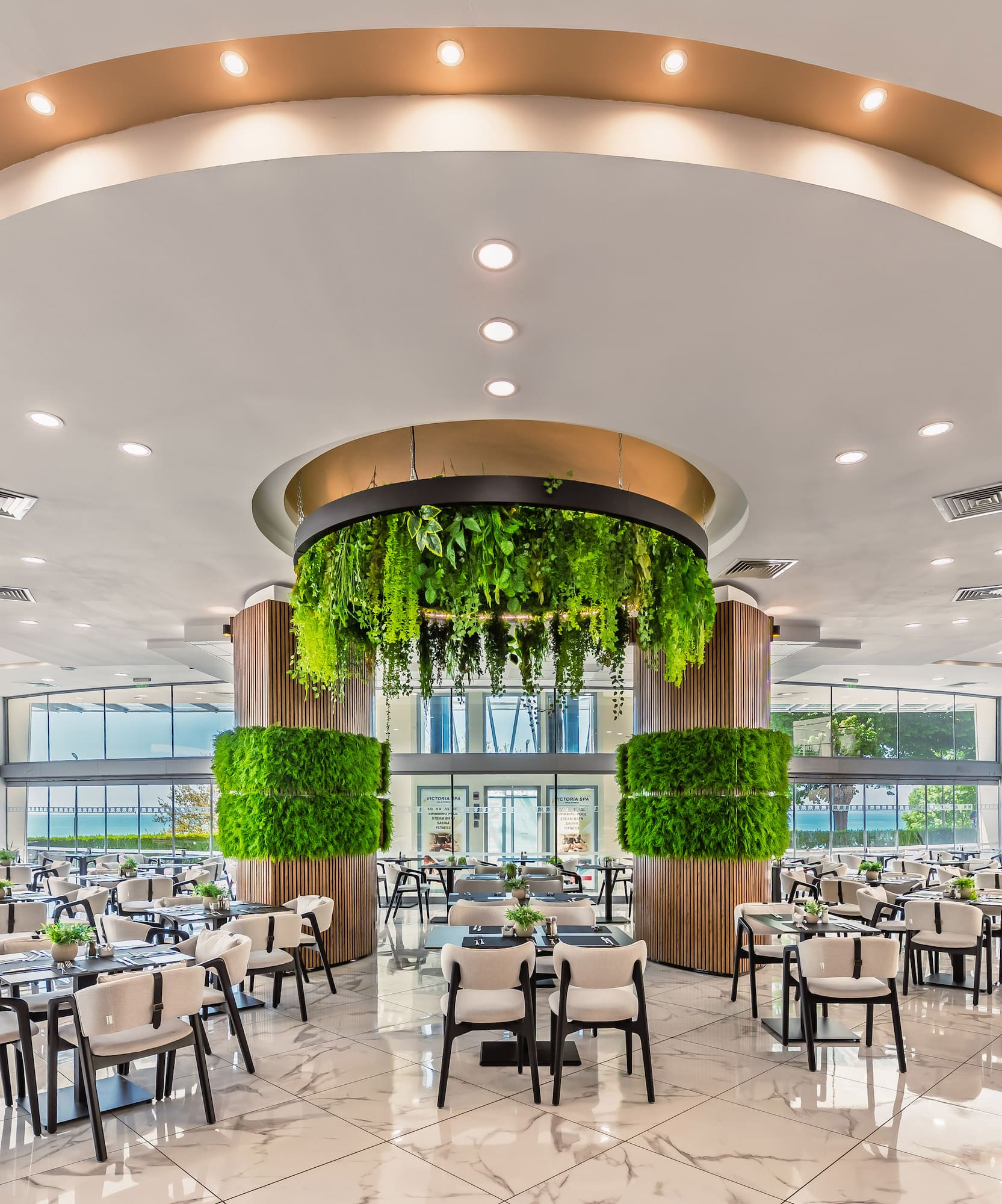 Modern elegant restaurant dining area with lush green plant decorations.