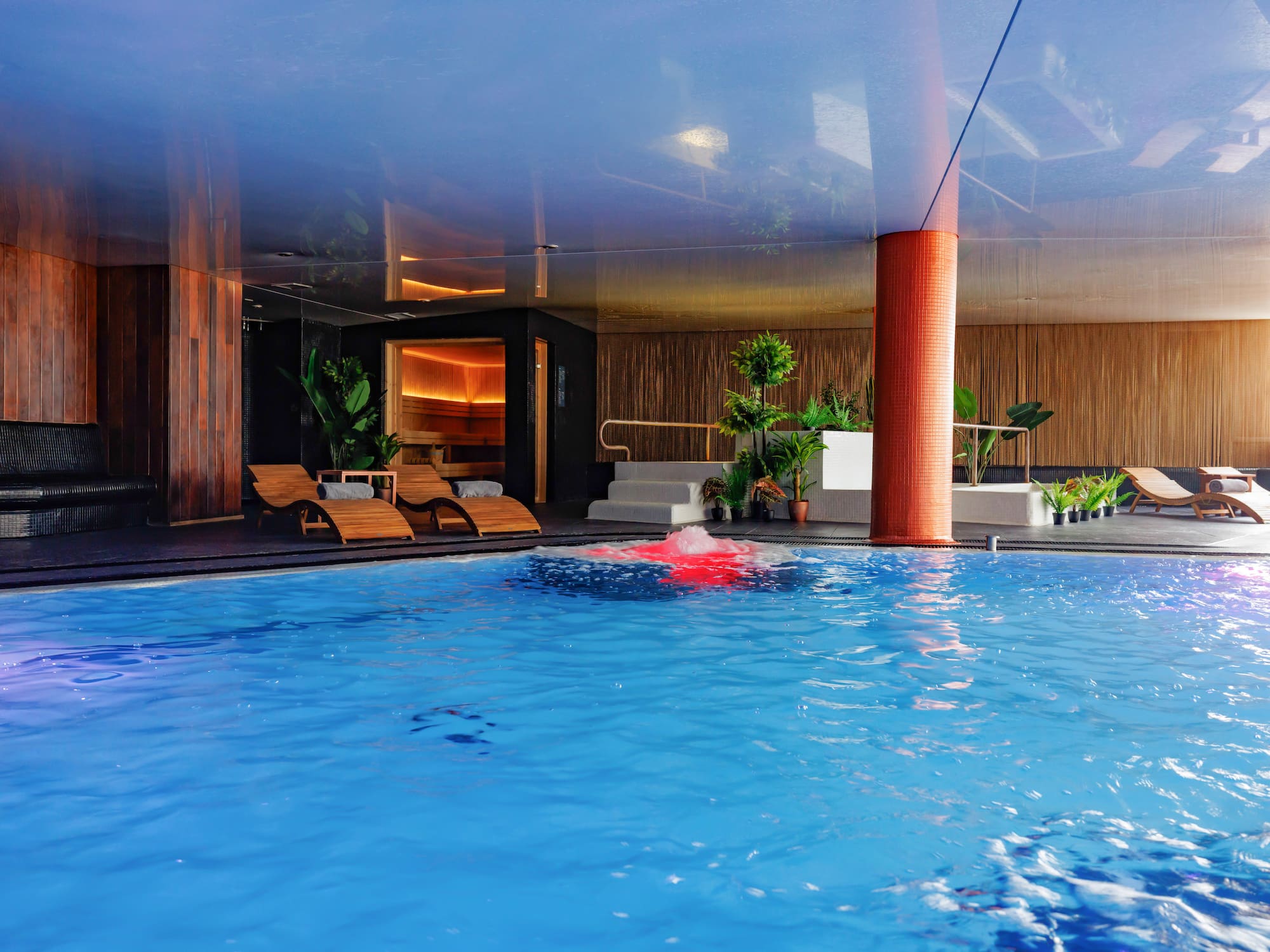 a pool with chairs and a red object in it