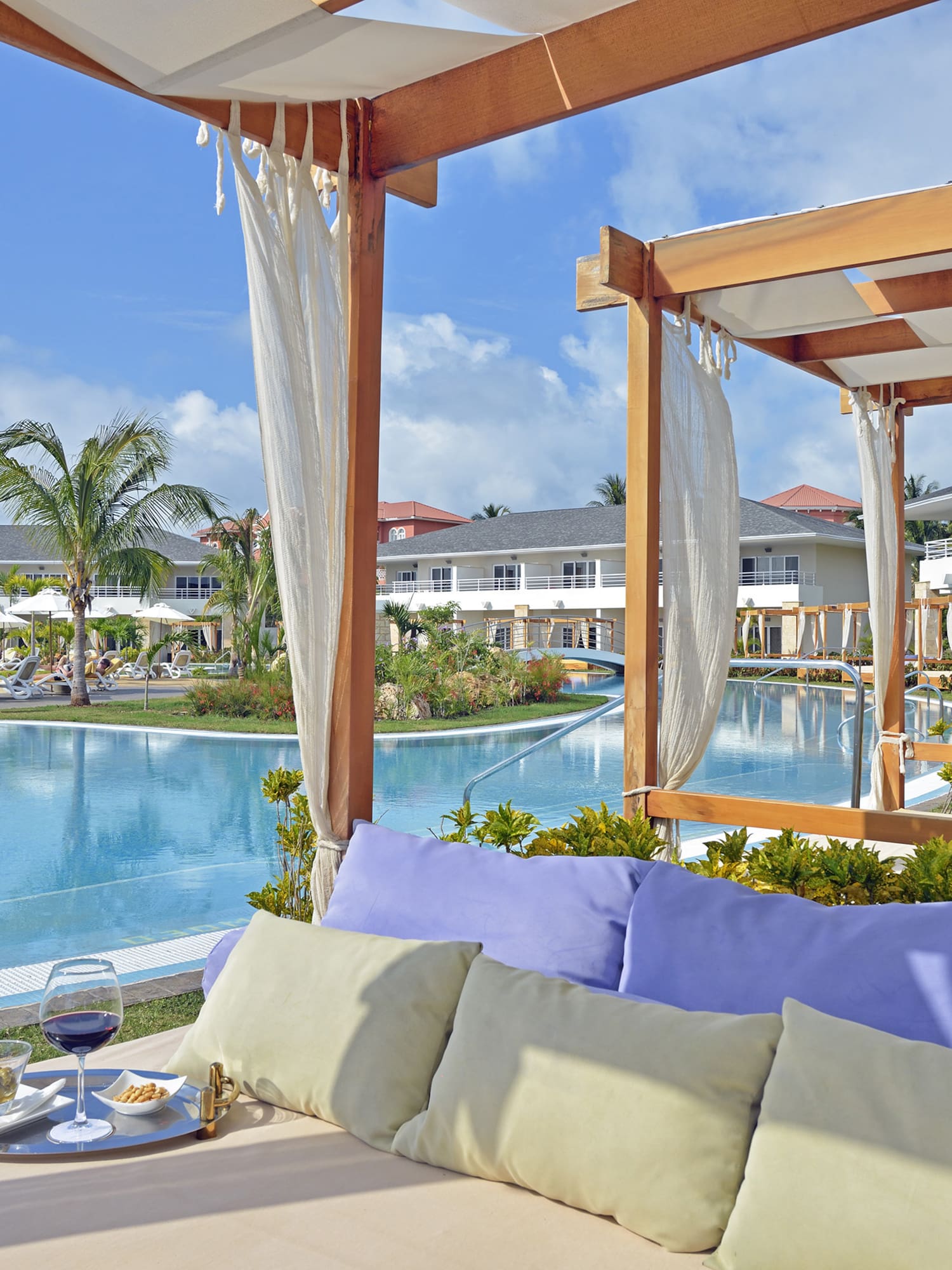 a pool with a couch and a tray of wine