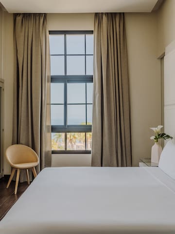 a bed with a chair and a window