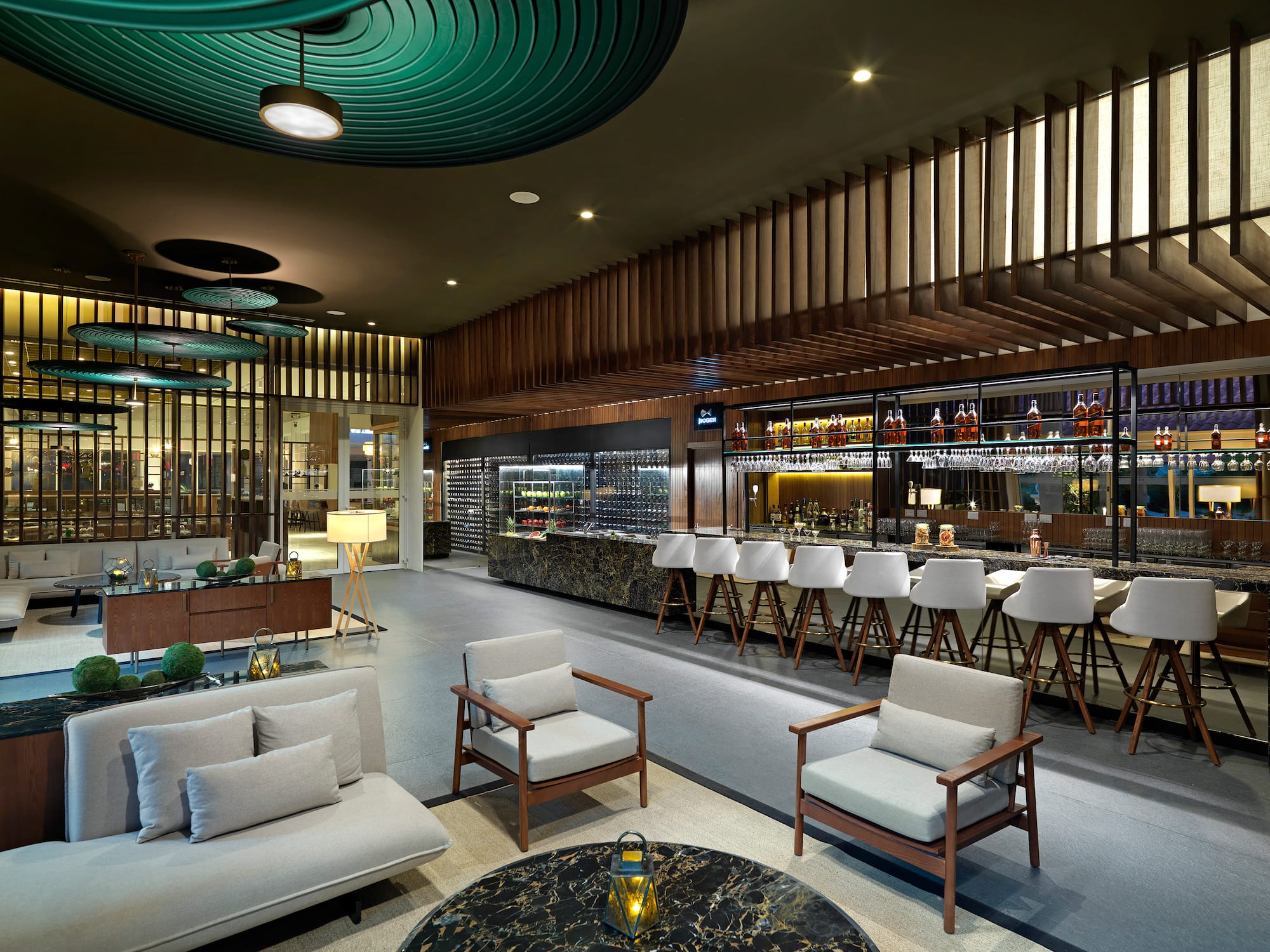 Lounge bar moderno con barra de mármol, asientos elegantes y bodega de vinos.