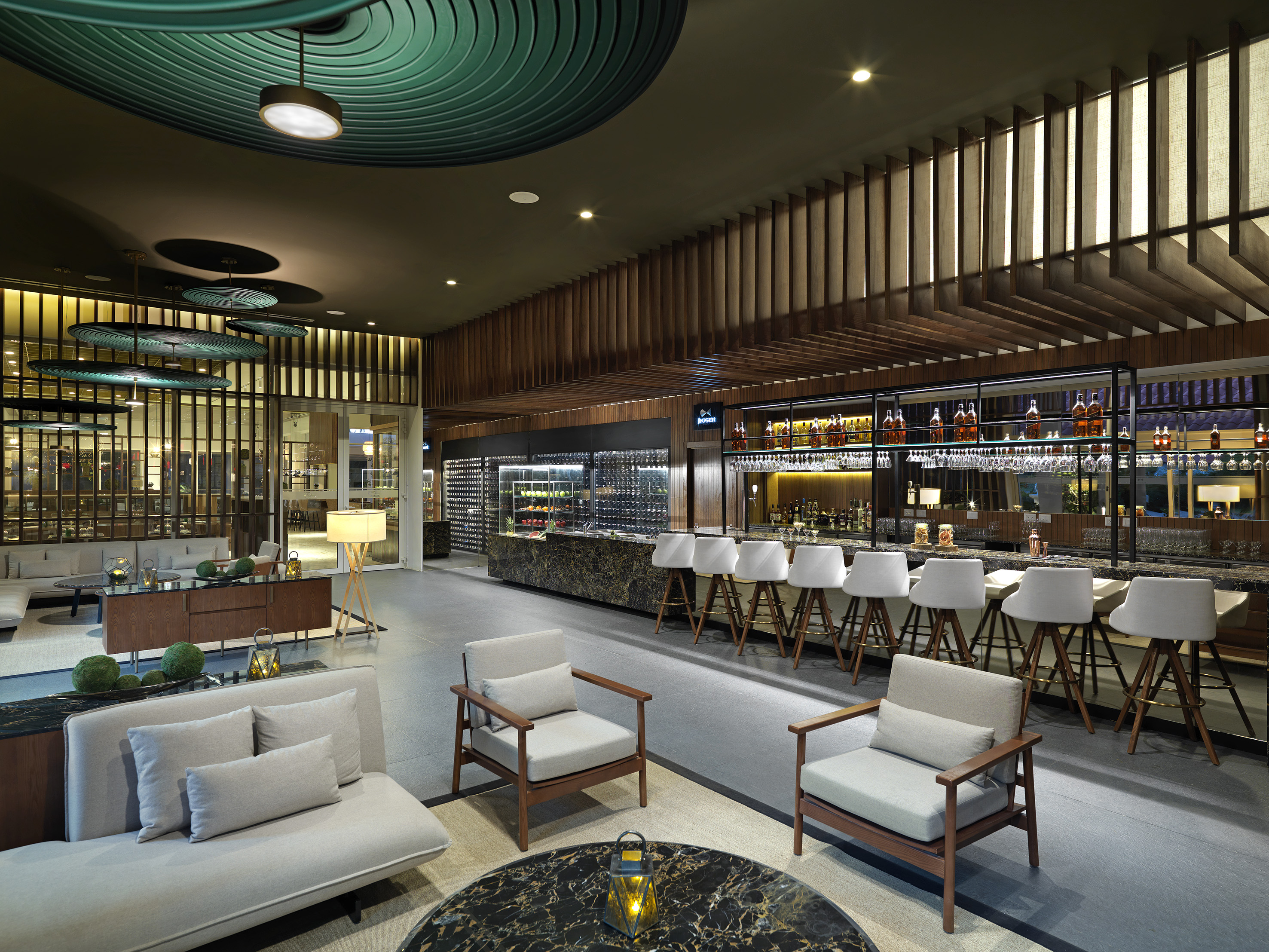 Lounge bar moderno con barra de mármol, asientos elegantes y bodega de vinos.