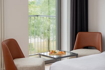 a tray of food on a glass table next to a bed and chairs