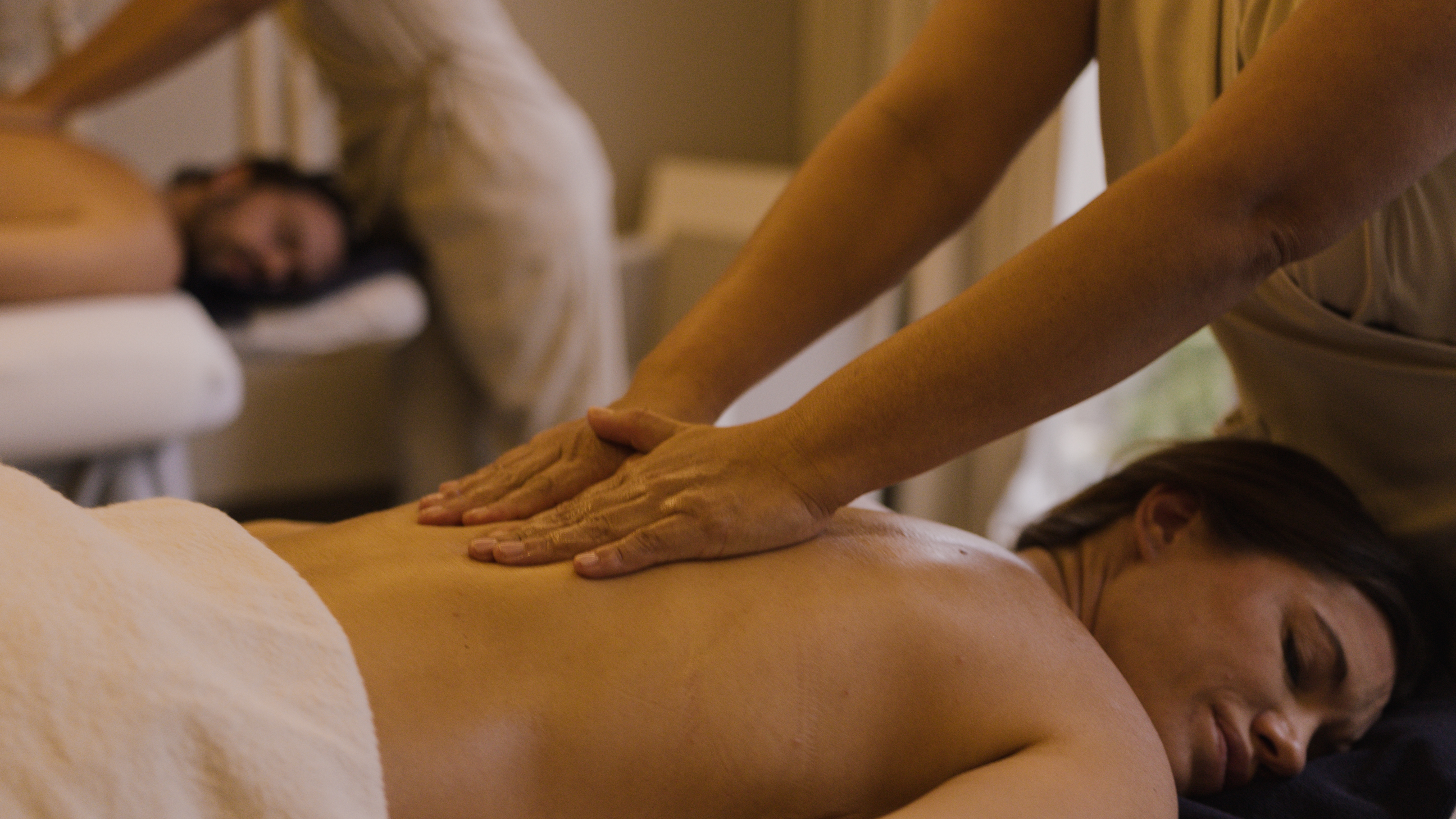 a person massaging a woman's back