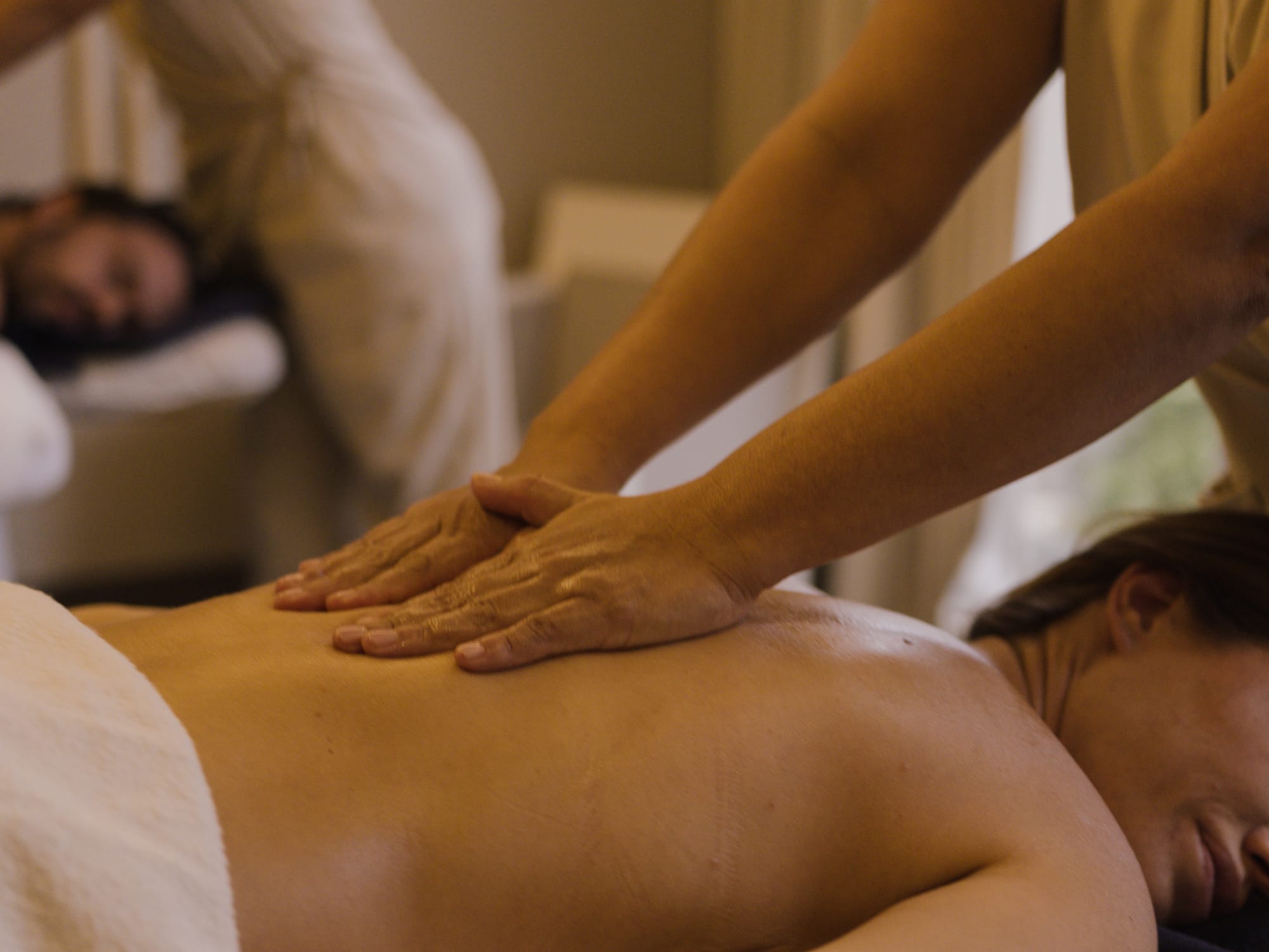 a person massaging a woman's back