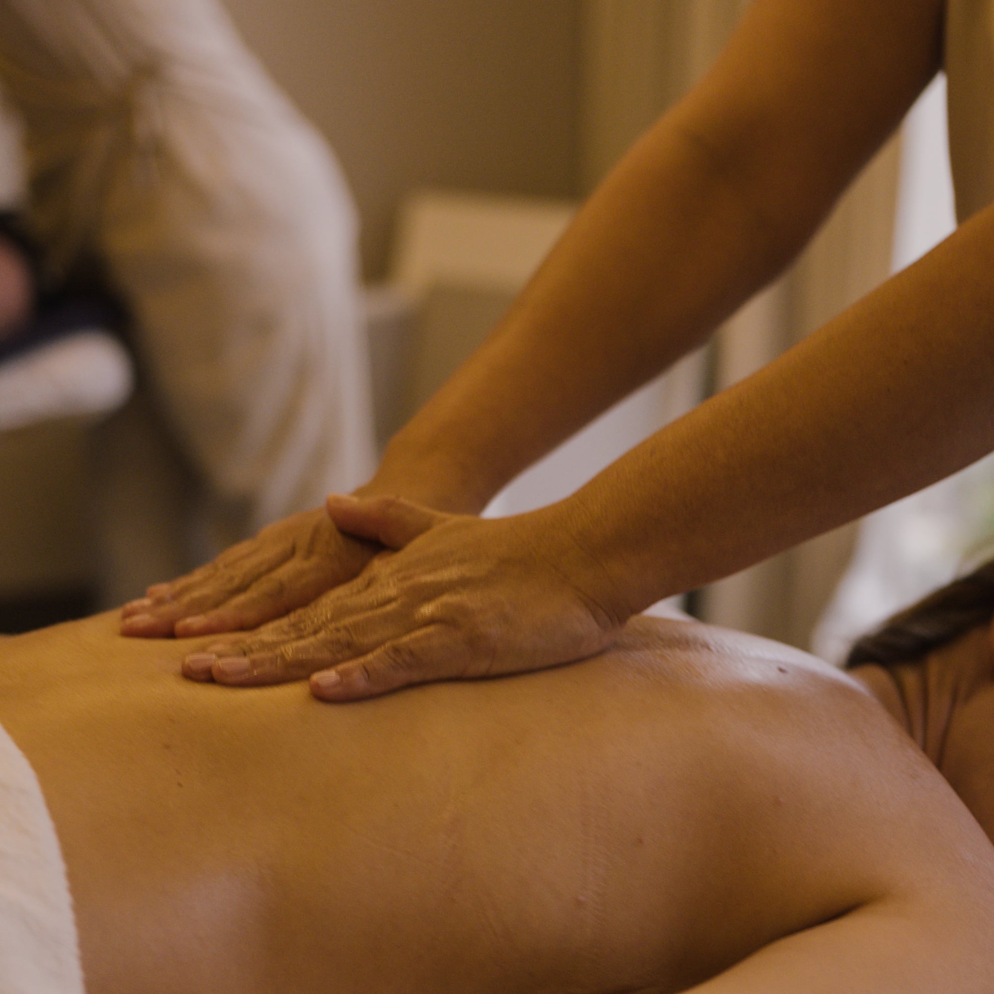 a person massaging a woman's back