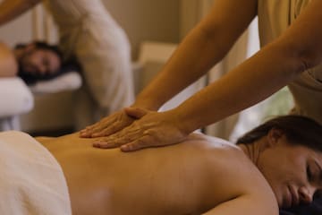 a person massaging a woman's back