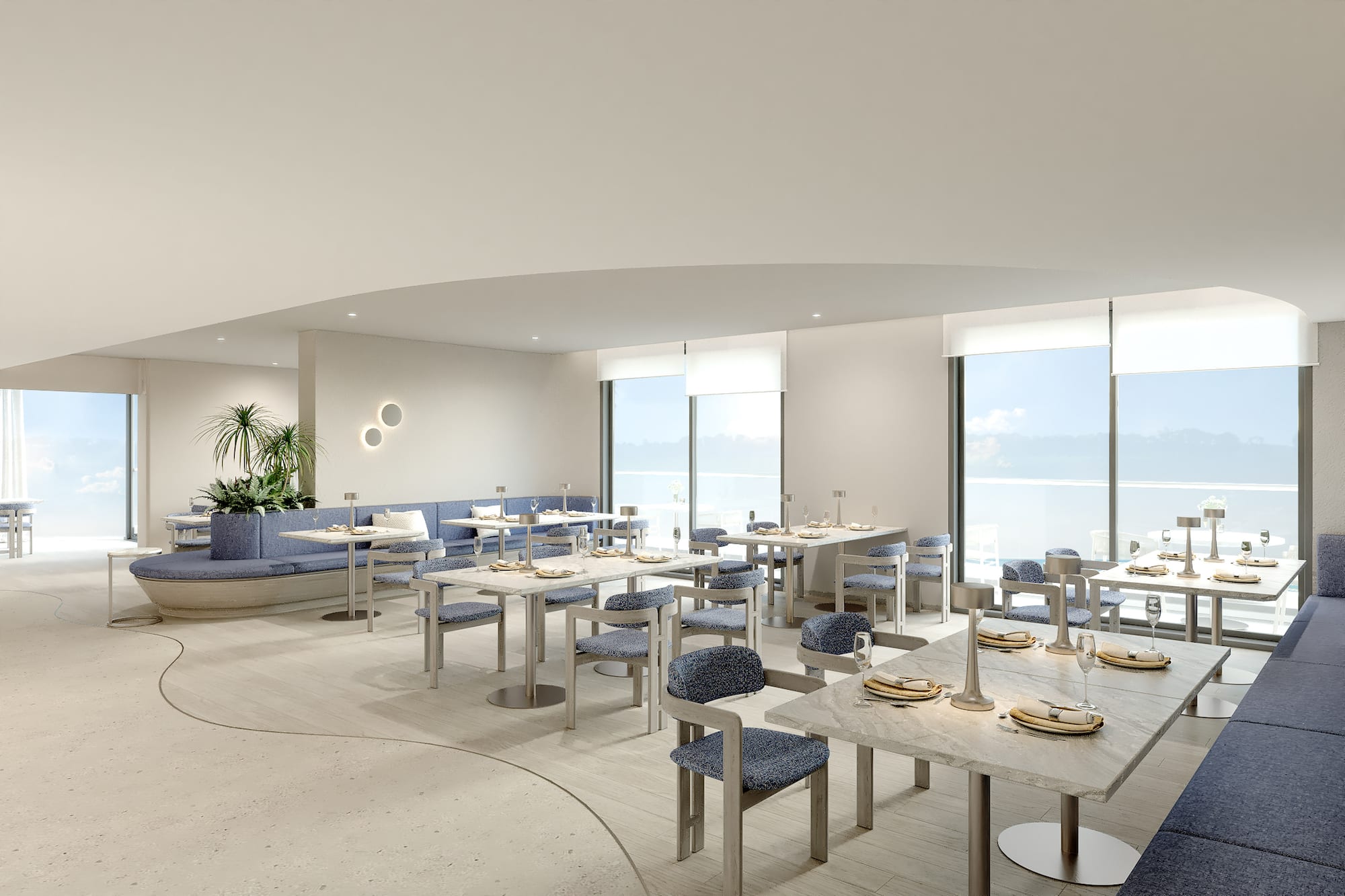 Contemporary restaurant with blue seating, marble tables, and ocean view.