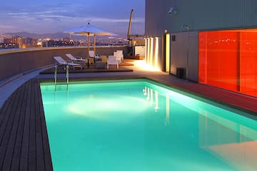 a pool with a deck and umbrella on a rooftop