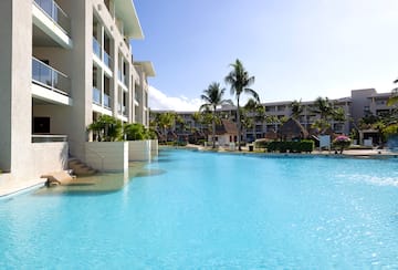 a pool with palm trees and buildings in the background